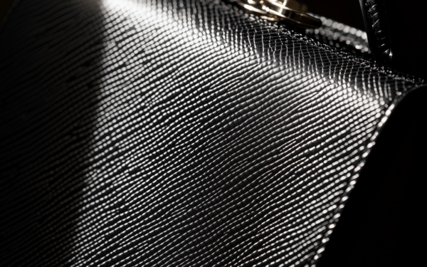 Saffiano leather handbag close-up showing the distinctive crosshatch texture and rigid structure